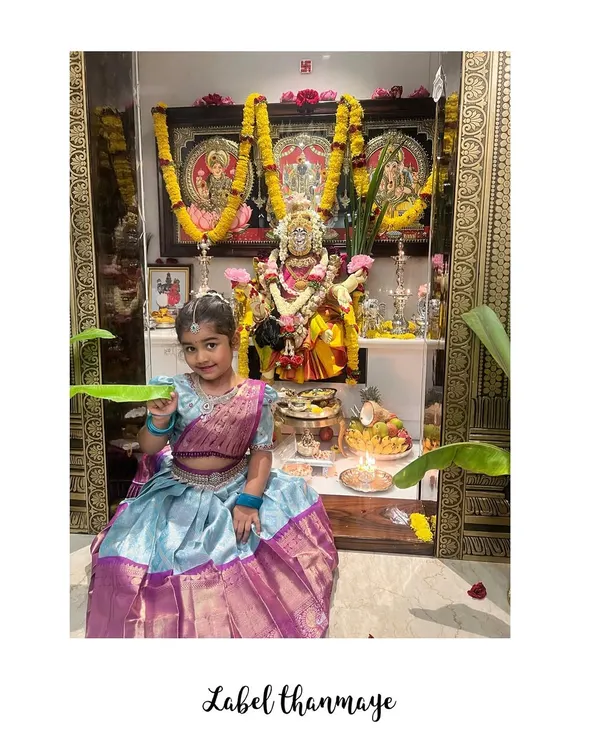 A little client dressed in a custom langa blouse for Varamahalakshmi pooja. The skirt is sky blue with a rich purple border.