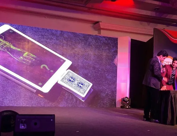 This is where technology and illusion collide on the big stage. For this corporate show, I created a custom digital illusion where a chosen card magically materializes from an iPad displayed on a massive LED screen, creating a high-impact moment for the entire audience.