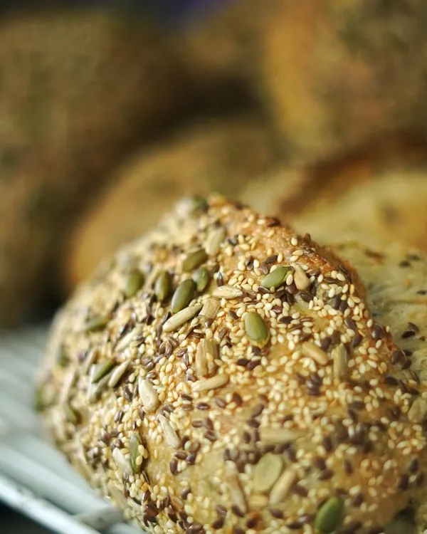 A close-up of our multi-seed bread, packed with sunflower seeds, pumpkin seeds, sesame, and flax. We believe in the power of whole foods and incorporate seeds and nuts into our baked goods for added nutrition and flavor.