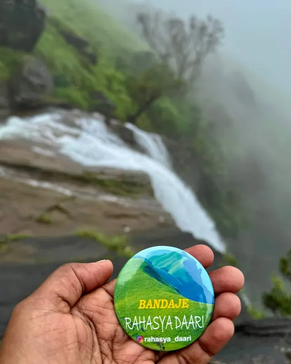 My custom "Bandaje Rahasya Daari" badge against the backdrop of the falls. I love creating little souvenirs to make your trip extra special.