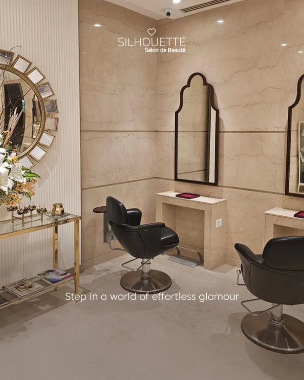 Step into a world of effortless glamour. This corner of our salon, featuring plush black leather chairs and elegant decor, is designed to provide a sophisticated and comfortable grooming experience.