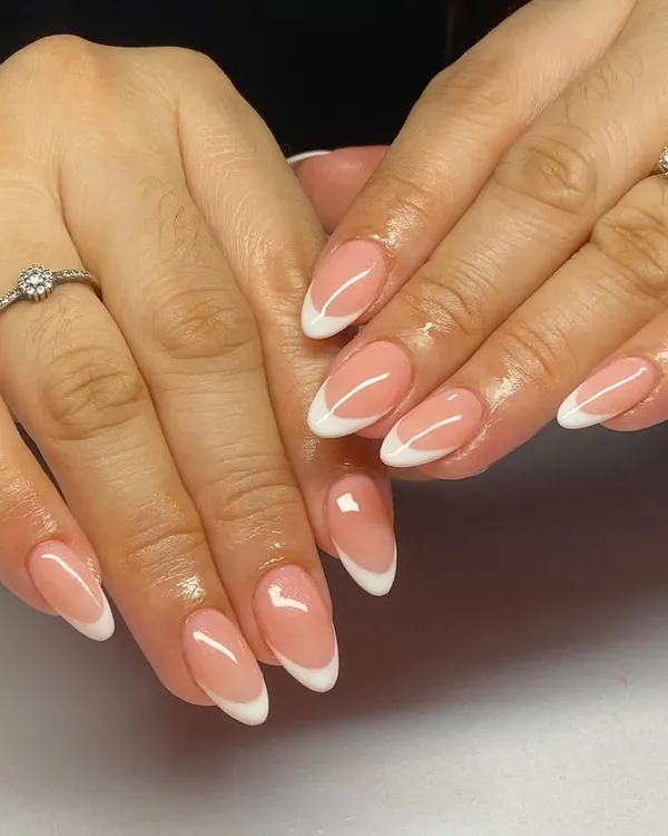 A perfect example of classic almond-shaped French manicure. The clean white tips and natural pink base are ideal for a sophisticated, everyday look.
