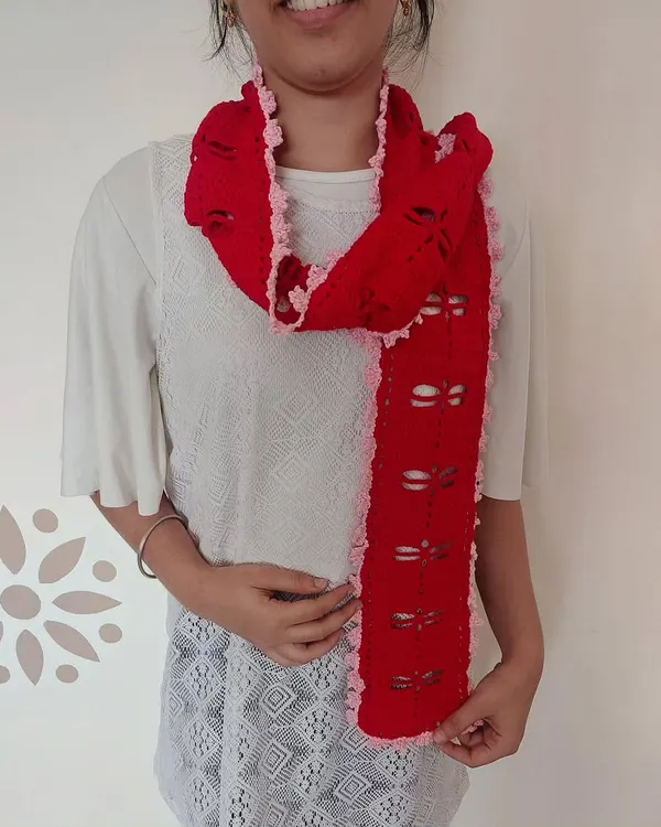 This is the Aerith Scarf, a beautiful and delicate piece featuring a filet crochet dragonfly pattern and a lovely ruffled edge.