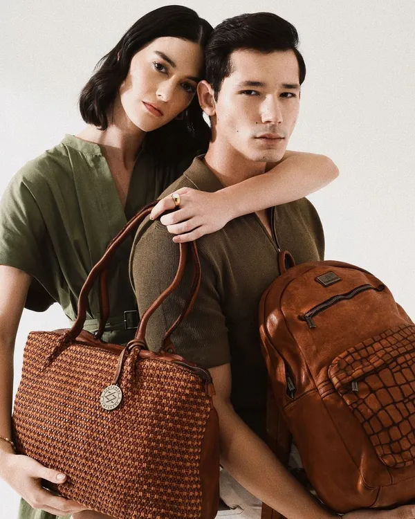 A chic campaign image for Kompanero leather goods. This shot showcases both men's and women's accessories, highlighting the brand's versatility and the quality of their woven leather bags.