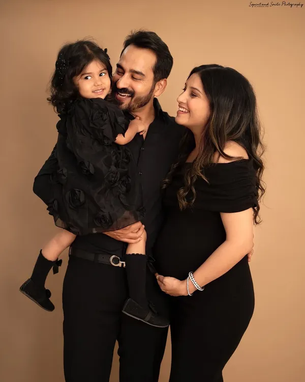 A classic portrait of a family of three, soon to be four. The way they look at each other, full of love and excitement, is what makes this maternity photo so special.