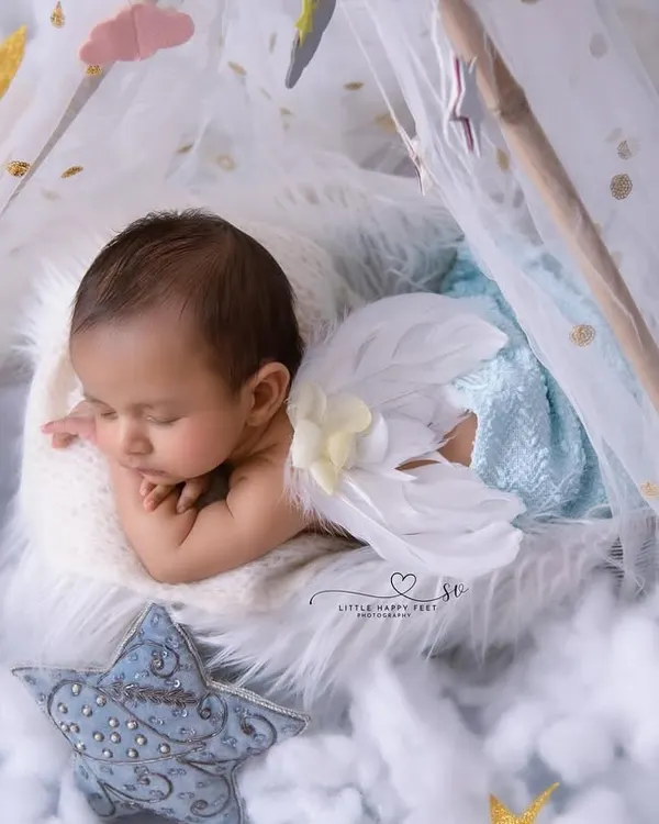 An angel sleeping on a bed of clouds. With delicate wings and a starry backdrop, this setup is perfect for capturing the heavenly innocence of your newborn.