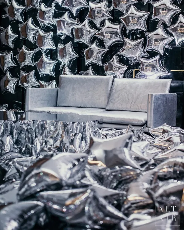 Welcome to 'The Melting Disco Ball', an after-party where we transformed a basement into a surreal disco experience. This photo booth, with its wall of silver star balloons and fringe, set the tone for a night of glam.