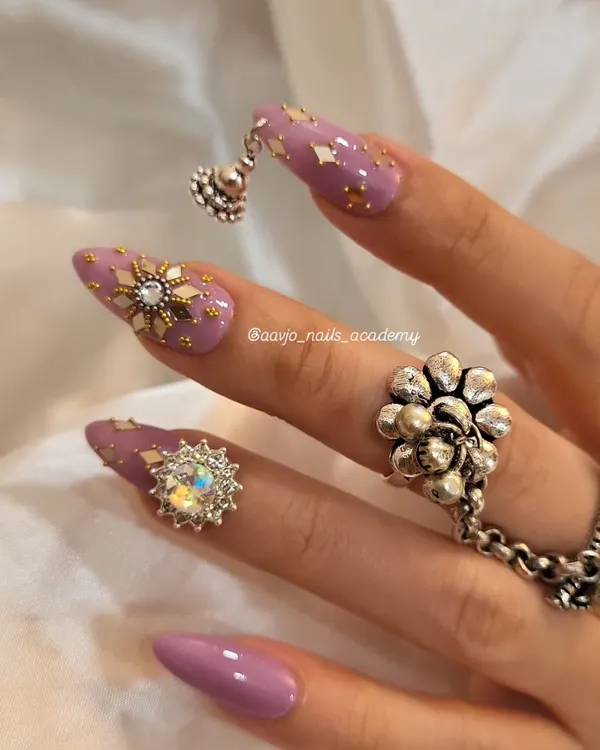 A stunning Navratri look. This set features a beautiful purple base with gold foil flakes, intricate star charms, and a dangling 'jhumka' charm for a truly festive and traditional feel.