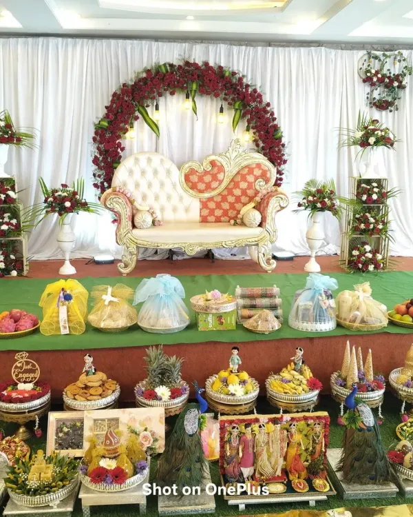 A full and elaborate Seer Thattu display for a traditional ceremony. This arrangement includes a wide variety of decorated platters, from fruits and sweets to beautifully wrapped gifts.