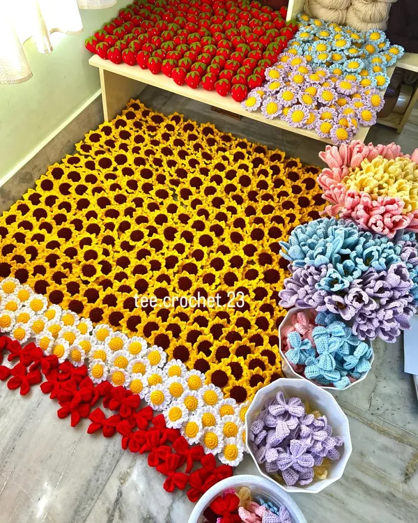 This is what a large wholesale order looks like before it gets packed up. I carefully arrange hundreds of handmade keychains, including sunflowers, daisies, strawberries, and bows, ensuring every single piece is perfect for my client.