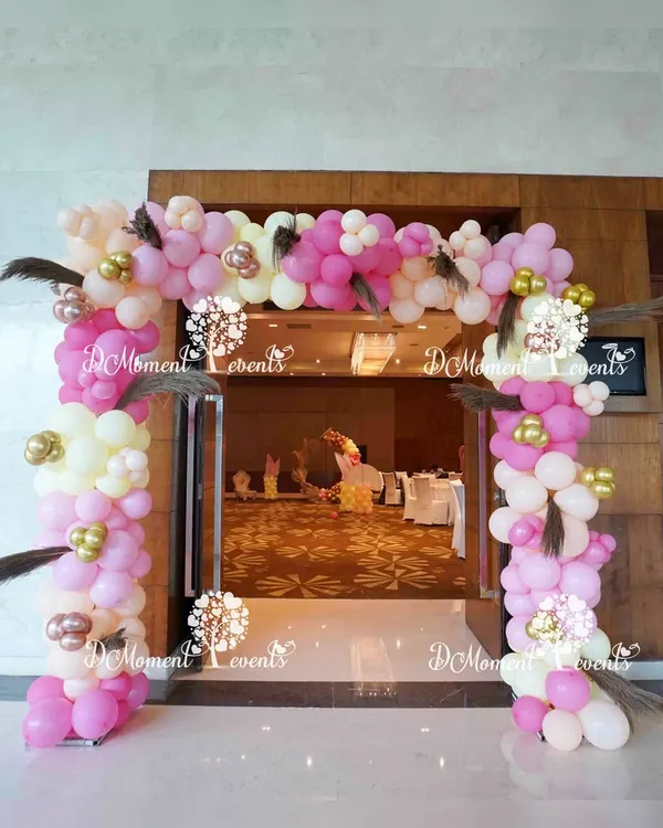 We designed this welcoming entrance arch for a baby's Annaprashan ceremony, marking their first taste of solid food. The boho-themed balloon arch in shades of pink, white, and gold is accented with pampas grass feathers, setting a warm and celebratory tone.