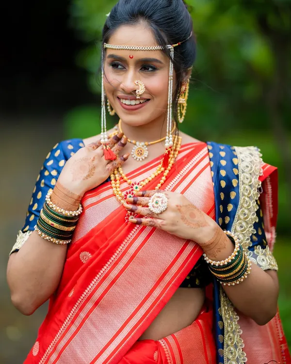 This is the essence of my work: a radiant Maharashtrian bride feeling confident and joyous. I created a clean, minimal base to let her natural beauty shine, paired with a classic red and blue Paithani saree, traditional mundavalya, and a delicate nath for a timeless wedding day look.