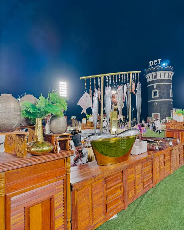 A spectacular seafood counter with a dramatic display of fresh fish like Surmai and Pomfret hanging over a rustic wooden setup. This station is a visual and culinary centerpiece for any grand event.