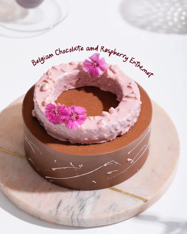 Our Belgian Chocolate and Raspberry Entremet, a stunning creation with layers of rich mousse, crunch, and confit, all dressed in edible elegance.