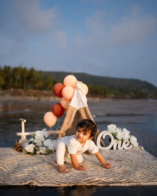 A little explorer crawling on the beach during his first birthday photoshoot. The natural setting and soft light create a beautiful, candid moment.