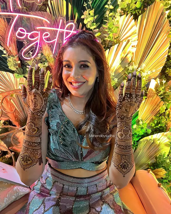 This bride's smile says it all! She looks absolutely stunning in her designer lehenga, and her custom mehendi was the perfect finishing touch for her sangeet look.