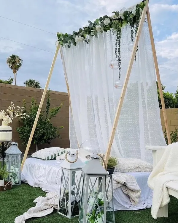 This elegant A-frame tent is perfect for a sophisticated outdoor brunch or sundowner. Dressed in sheer white fabric and florals, it provides a comfortable and stylish retreat for any celebration.