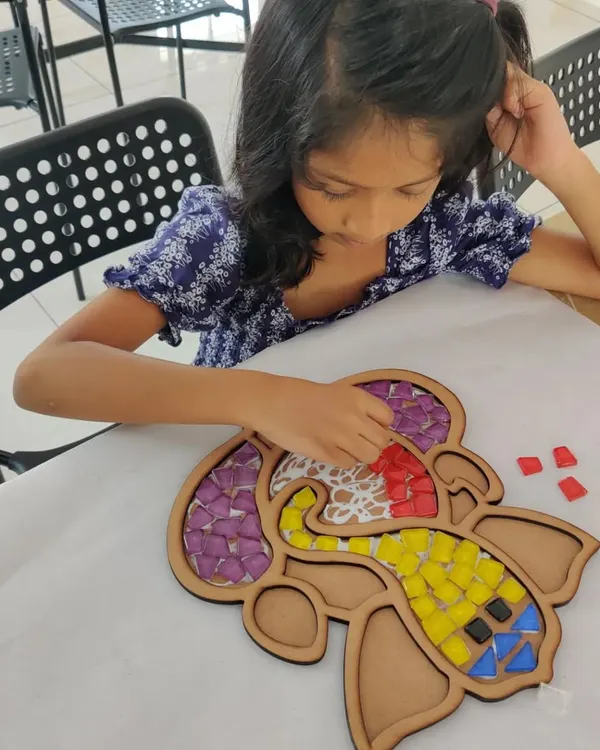This young artist is carefully placing tiles on a Ganesha mosaic base. It's a calming and rewarding activity that helps kids with focus and fine motor skills while they create beautiful art.