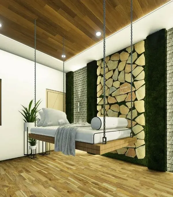 A unique balcony design transformed into an outdoor room with a hanging swing bed. The feature wall combines natural stone and vertical green panels, creating a tranquil escape.