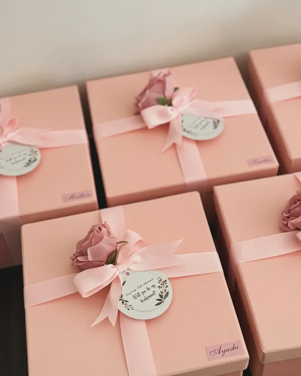 The excitement begins with the box! These pretty pink bridesmaid proposal boxes are all ready to be filled with love and goodies. Each one is personalized with a name sticker and a "Will you be my bridesmaid?" tag.