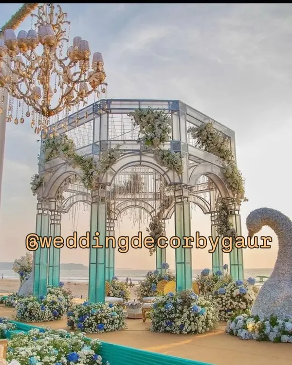 A breathtaking seaside mandap we constructed for a beach wedding in Goa. This custom-built glasshouse structure, adorned with blue and white hydrangeas, created a magical setting against the ocean backdrop.