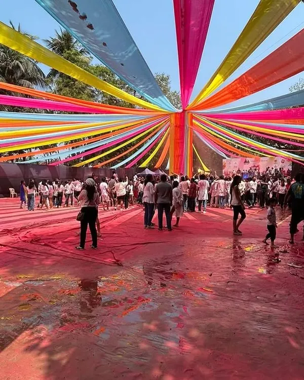A wide-angle view of the 'Rang De' Holi party setup at Shivaji Park. You can see the scale of the multi-colored fabric draping that created a festive canopy over the entire ground, accommodating a houseful crowd.