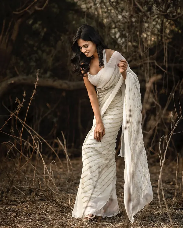 This image from a shoot in a natural setting captures a candid, gentle moment. The model's downward glance and the soft focus of the background create a serene and thoughtful mood, perfect for a lifestyle portrait series.
