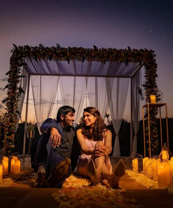 A romantic evening setup with a couple surrounded by candles and soft drapes. This is an example of a styled, intimate shoot we can create for a special occasion or proposal.