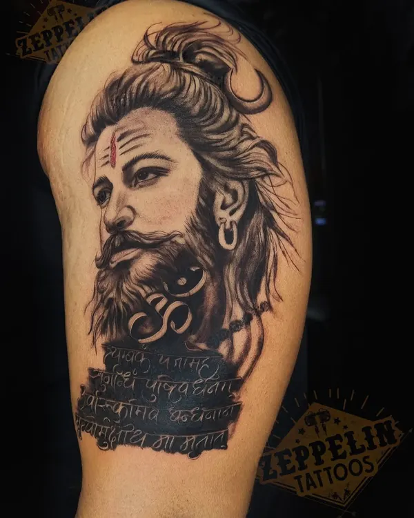 A portrait of Lord Shiva for a client's upper arm. I focused on creating a realistic yet powerful expression, combining it with the Om symbol and the Maha Mrityunjaya mantra for a deeply spiritual piece.