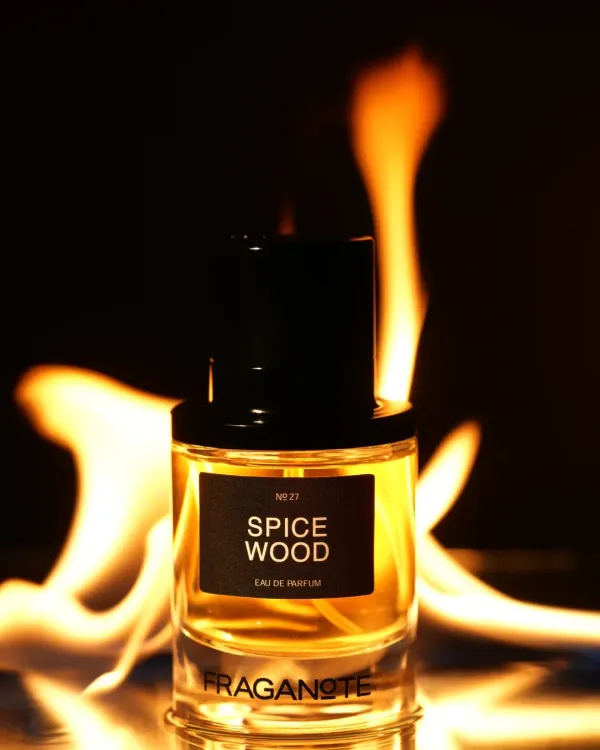 A bottle of 'Spice Wood' perfume dramatically lit with real flames in the background. We use practical effects like fire and smoke to create bold, powerful images for masculine fragrances.