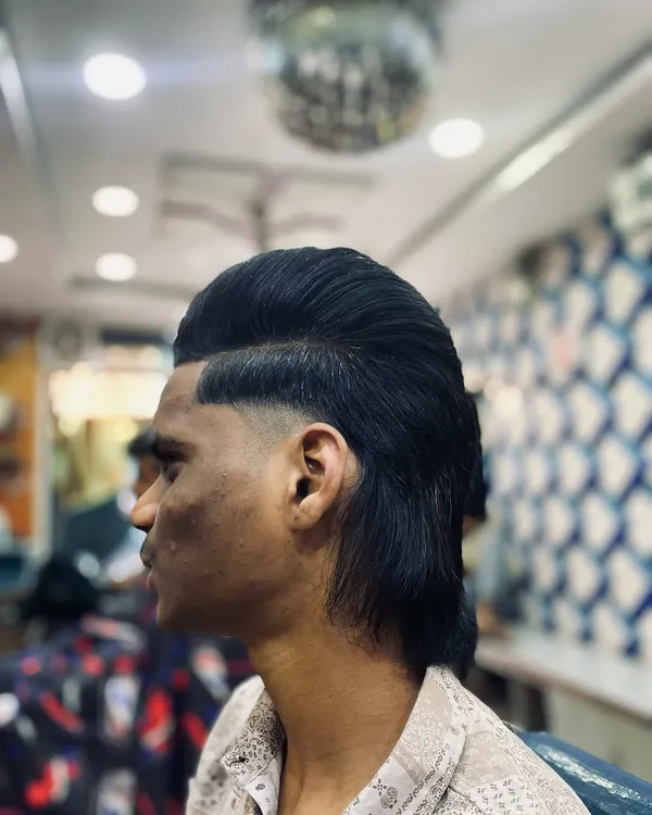 The modern mullet is one of my specialties. I keep it fresh with a seamless fade on the sides, a styled pompadour on top, and a clean, flowing look at the back.