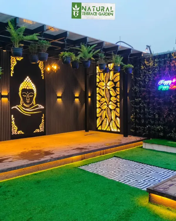 A custom-made, backlit Buddha jaali panel serves as a peaceful and artistic focal point in this Uttam Nagar pergola.
