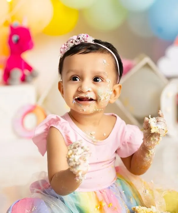 The pure joy of discovering cake for the first time! This little one's messy hands and face during her rainbow-themed cake smash session is exactly the kind of happy, authentic moment I love to capture.