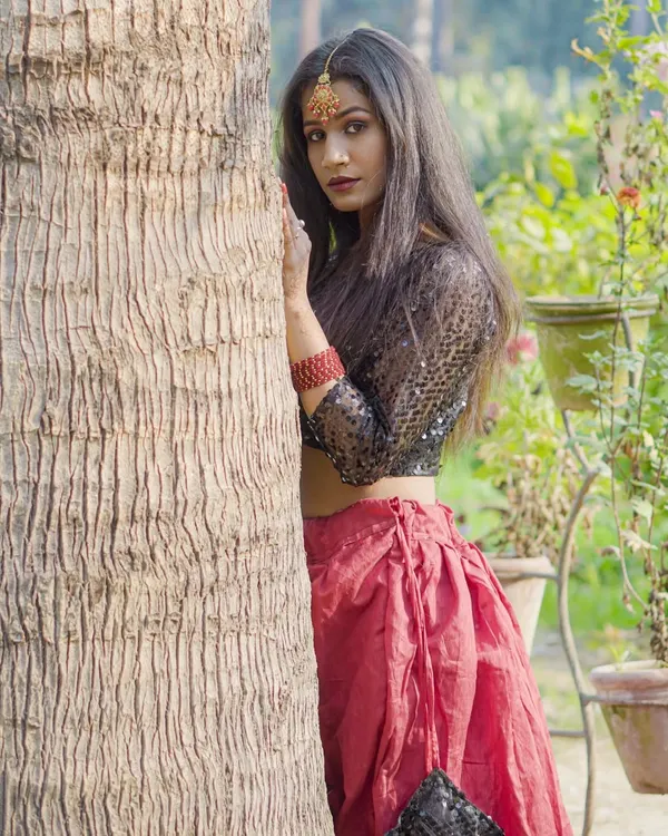This outdoor fashion shot shows how I use natural light and surroundings to create a striking, editorial look. The model is wearing an ethnic fusion outfit with a sequined top and red skirt, perfect for a modeling portfolio.