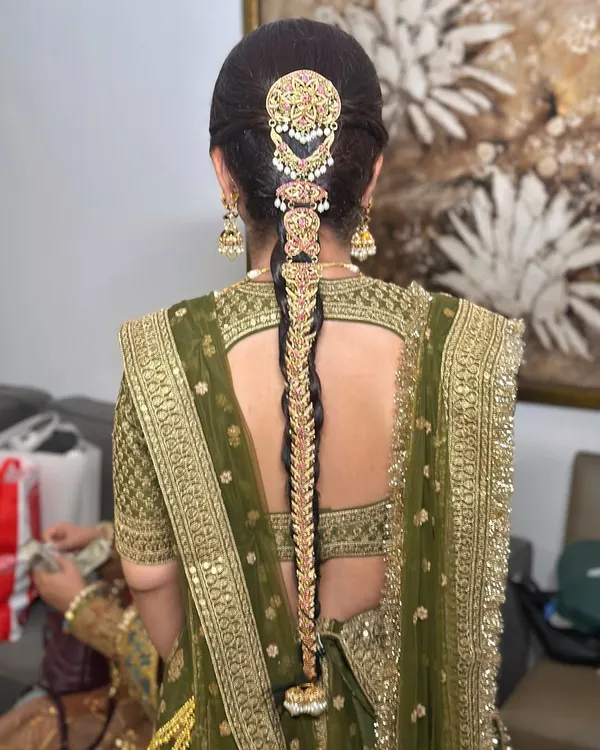 A classic traditional bridal braid for a Sabyasachi bride. I used an elaborate gold jadau hair accessory that covers the entire length of the braid, creating a look of pure royalty and heritage for her wedding day.