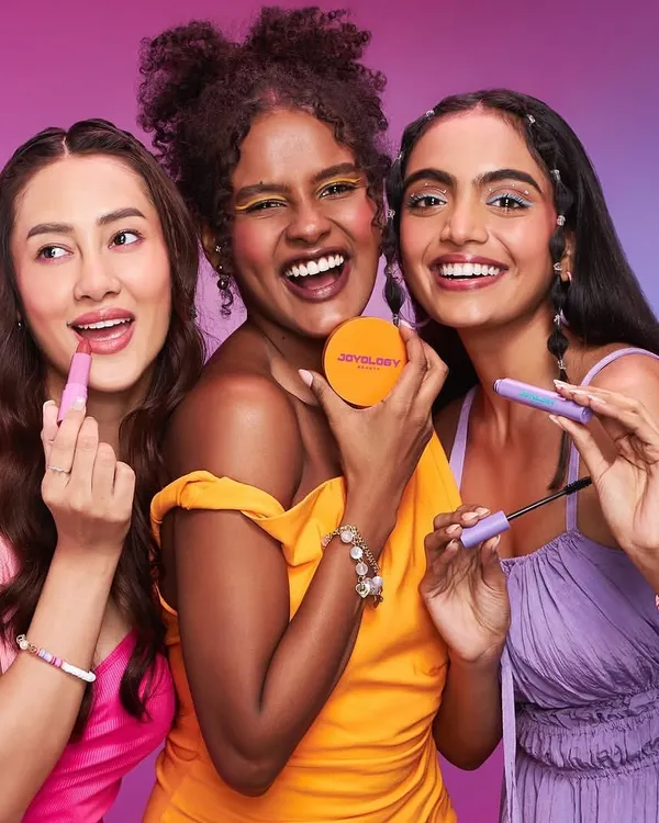 A vibrant beauty campaign shot featuring three models with joyful expressions. The makeup is colorful and fresh, showcasing a range of lipstick and eyeshadow shades, and highlighting my ability to work with diverse skin tones.