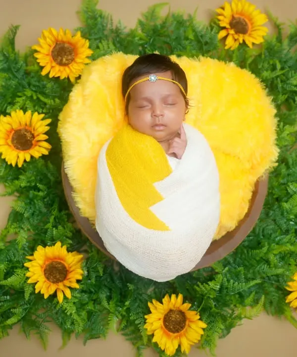 We design adorable themes to match your little one's sweetness. This newborn is safely swaddled and surrounded by bright sunflowers, creating a cheerful and heartwarming portrait that you will cherish forever.