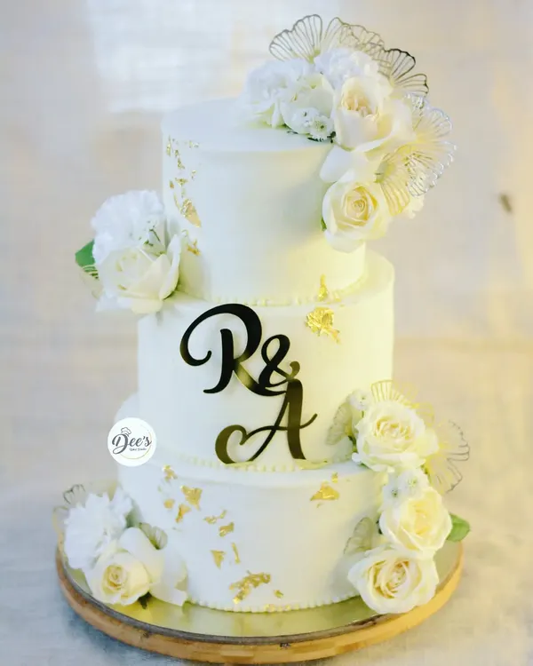 This three-tier all-white wedding cake is the definition of classic elegance. I adorned it with fresh white roses and delicate gold leaf accents for a timeless and sophisticated look.