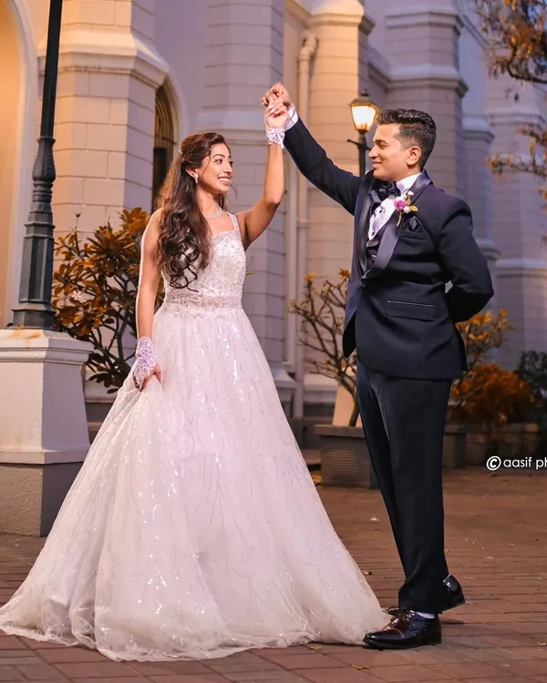 A dance with her prince charming. This beautiful couple is captured outside the church, showcasing the bride's stunning white ball gown and the groom's classic tuxedo.