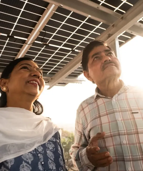 A couple admiring their new rooftop solar installation as the sun sets. We are proud to have helped thousands of families like them switch to clean energy and secure a brighter future.