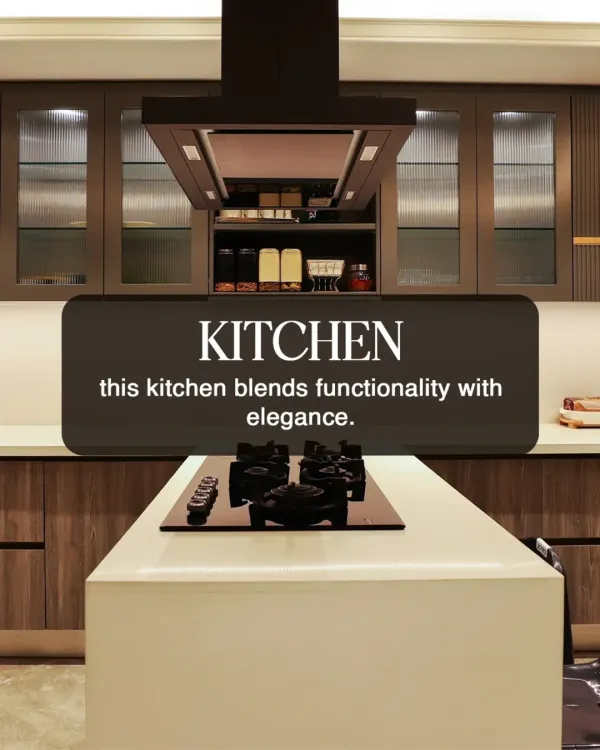 This kitchen blends elegance with functionality. The design features an island with a built in cooktop, a powerful chimney hood, and fluted glass cabinets for a sophisticated touch.