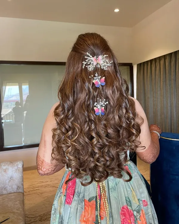 How dreamy is this Mehendi hairstyle? My hairstylist created these gorgeous, bouncy curls and adorned them with these whimsical butterfly clips for a fun and festive look.