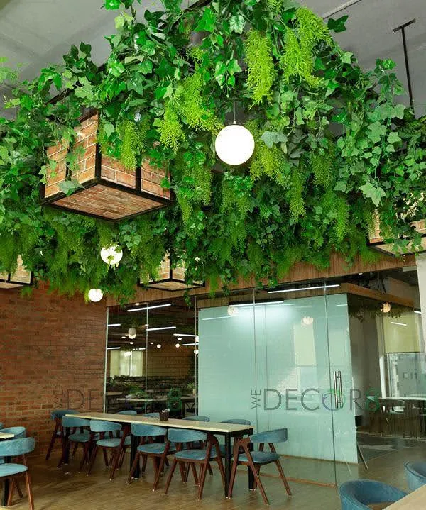Our hero installation showcases how we can completely transform a corporate cafeteria into a vibrant, living space. This custom overhead greenery structure with integrated lighting creates an immersive biophilic experience, making the office feel more alive and energetic.