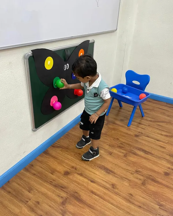 A young explorer interacts with our butterfly color matching board. This activity is part of our curriculum that uses nature themes to teach fundamental concepts like colors and counting.