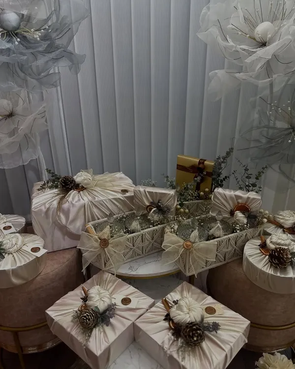 An example of a winter-themed trousseau setup using fabric wrapping, a technique we cover in detail. Notice the use of natural elements like pinecones and dried flowers to create a cohesive, luxurious look.