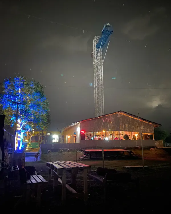 A stunning night view of our venue, prominently featuring the illuminated bungee jumping tower. This structure is central to our adventure offerings, providing a thrilling experience for daredevils.