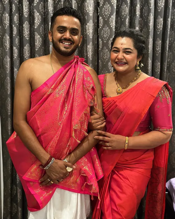 A happy client couple in their coordinated traditional outfits. I provided the custom-designed pink blouse for her to match his angavastram for their ceremony.