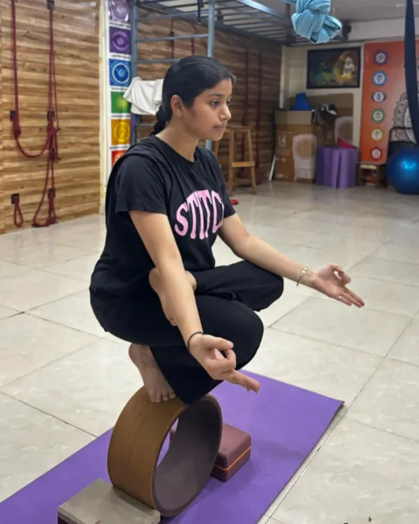 Finding stillness and balance on the yoga wheel. This pose requires immense core control and concentration, showing the connection between a quiet mind and a steady body.