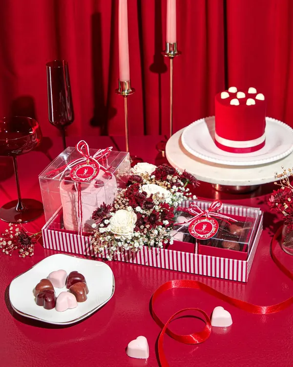 A romantic tablescape featuring our Valentine's Day collection. This hamper includes a mini red velvet cake, heart-shaped chocolates, and fresh flowers, all set for a celebration of love.