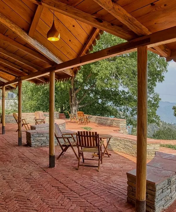The outdoor cafeteria at Sargakhet Handicraft Centre in Mukteshwar, set on a terrace with brick flooring. This space was created by transforming a dilapidated British-era Post Office into a hub for local artisans.